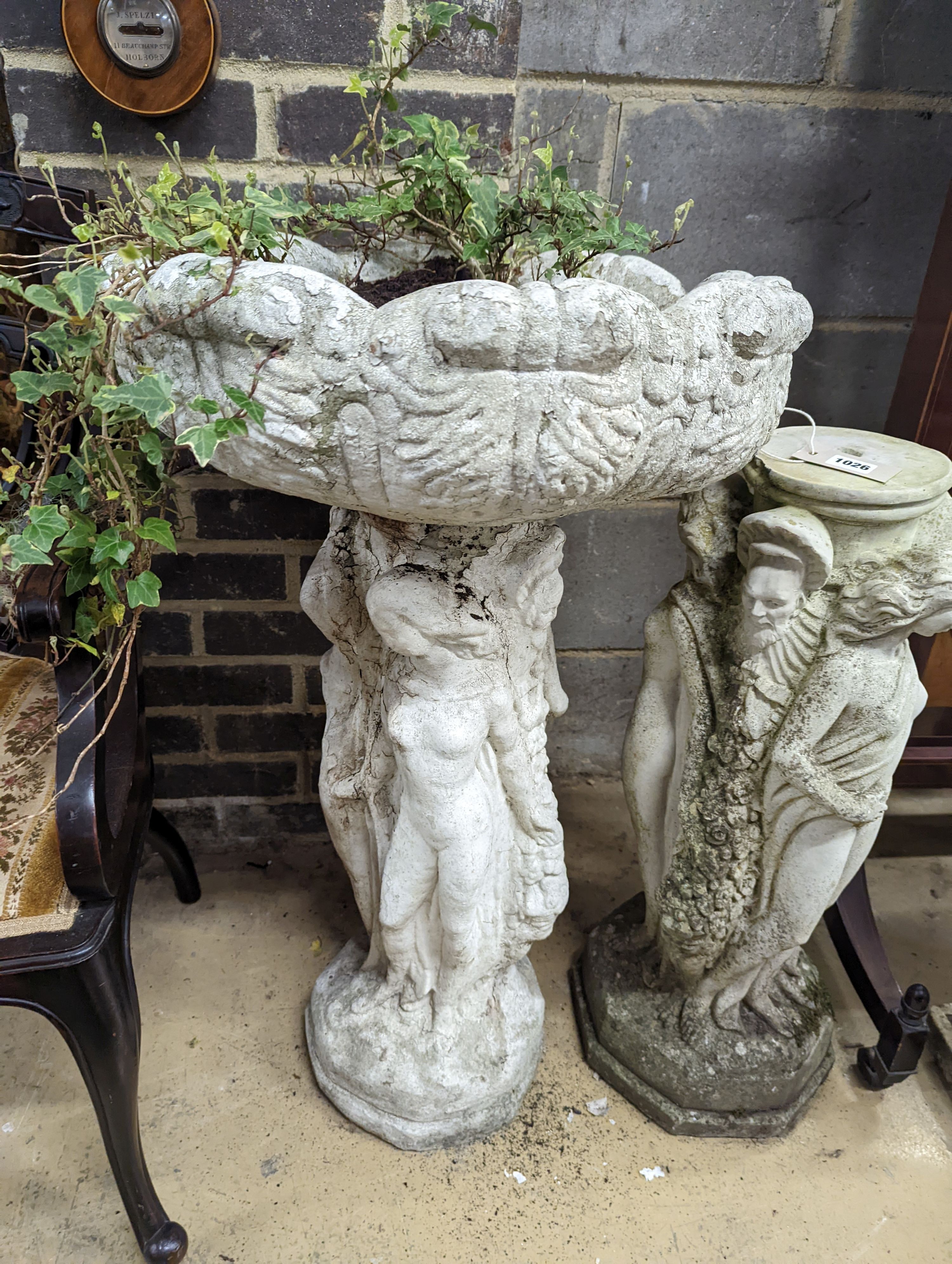 A circular reconstituted stone figural garden planter, diameter 48cm, height 82cm together with two stone bird baths and a plinth
